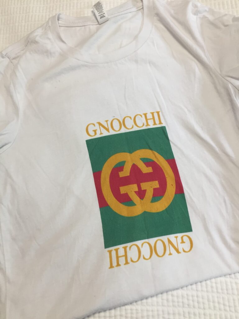 A white tshirt with the Gucci logo in the middle, with the words Gnocchi above it