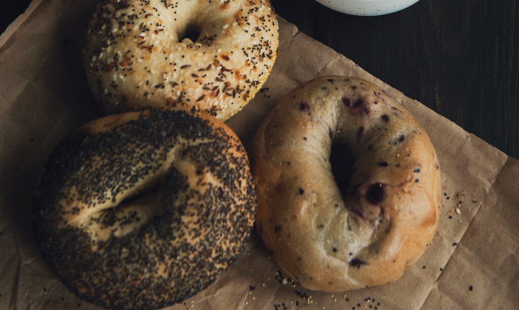 A photo of three bagels sitting on a brown napkin
