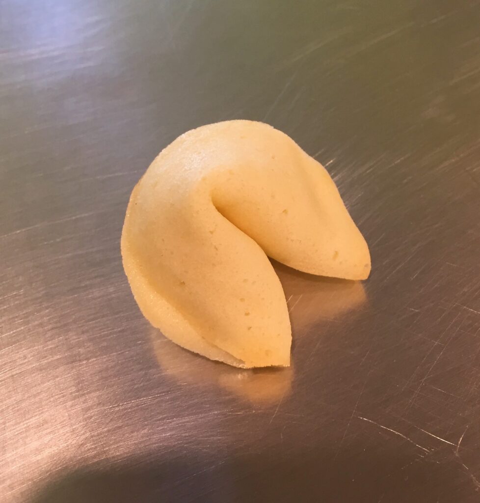 A picture of a homemade fortune cookie on a metal tray