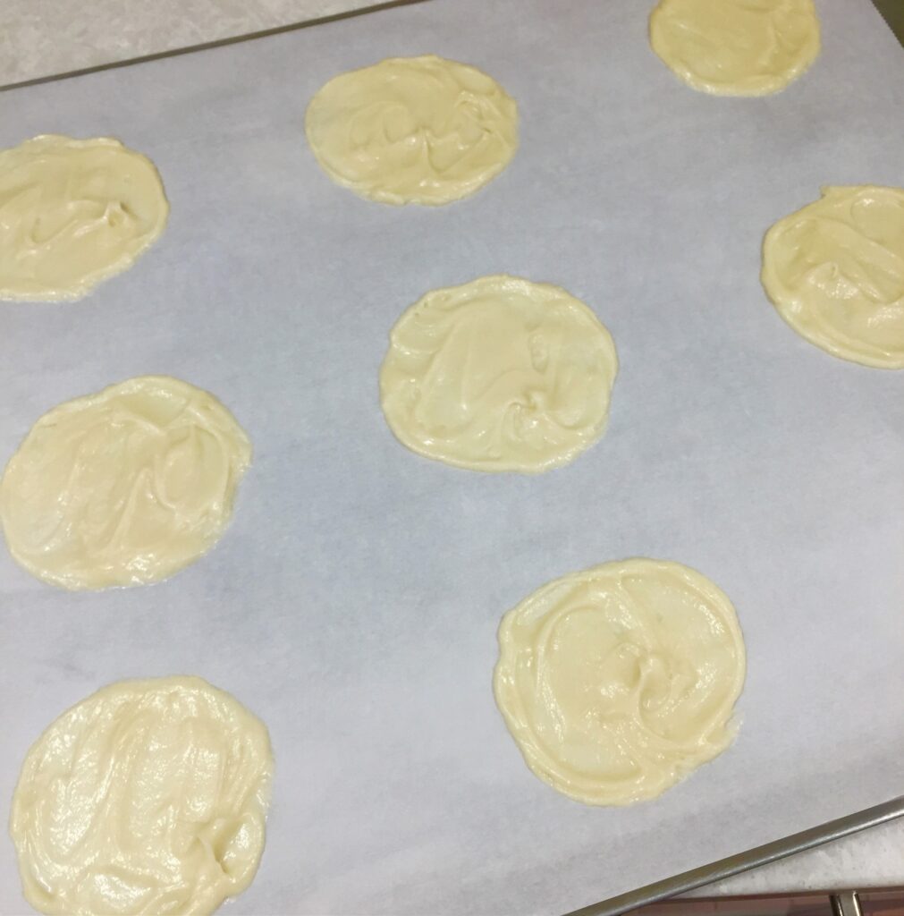 A picture of fortune cookie batter in circles on a baking tray