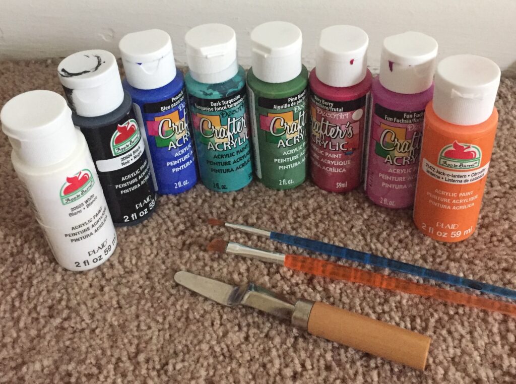 A picture of eight bottles of different colored acrylic paint