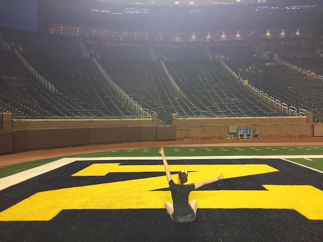 A picture of a girl on the field of the Michigan Stadium