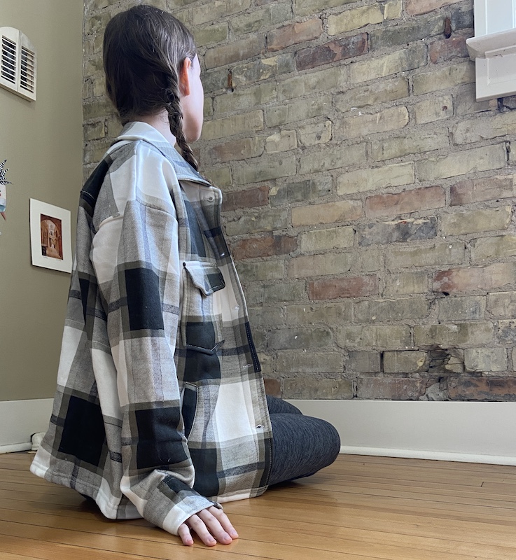 A picture of a girl wearing a sage green plaid jacket from FemmeLuxe