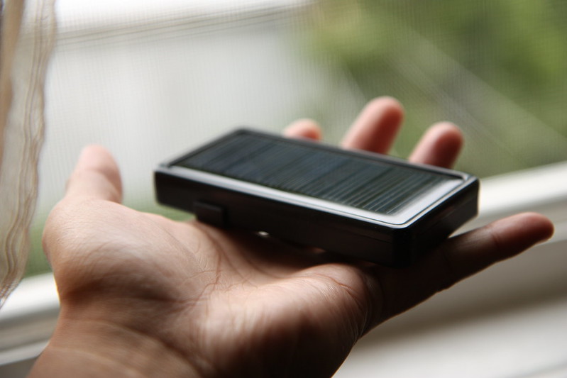 A picture of a hand holding a solar phone charger