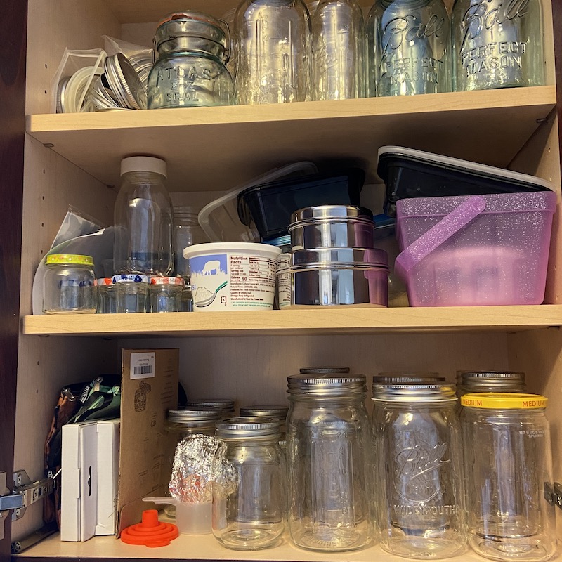 A picture of a cupboard full of mason jars
