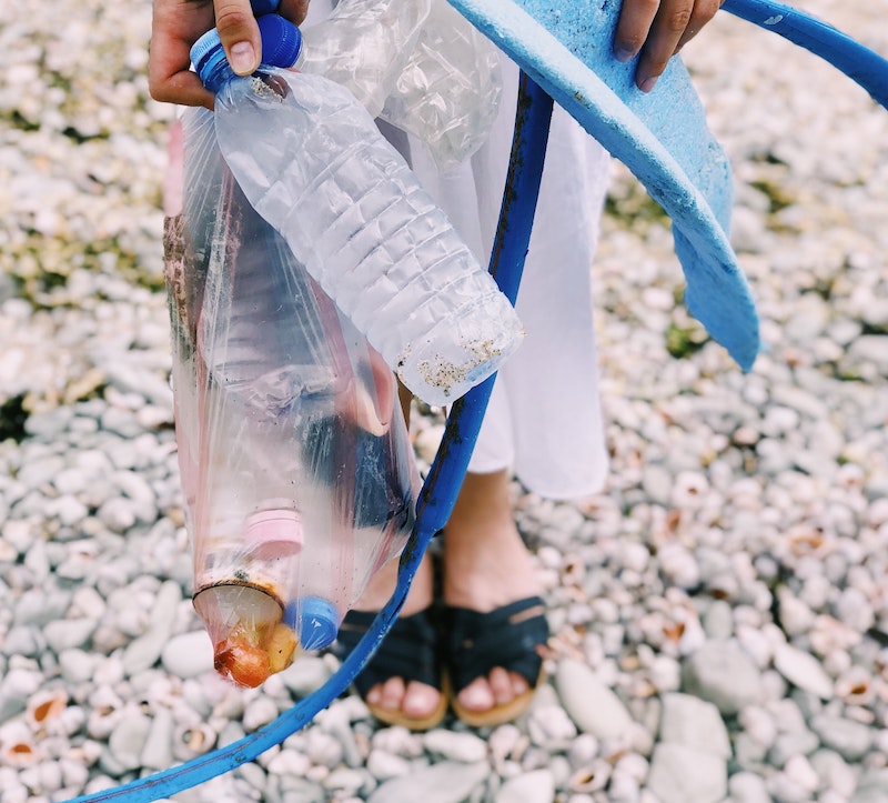 A picture of a girl holding trash on the beach