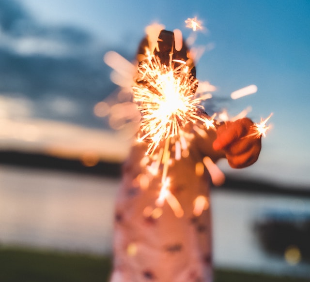A picture of a man holding a glowing sparkler