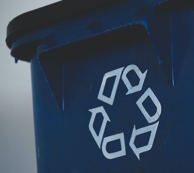 A picture of a blue recycling bin, with the recycle symbol on the side