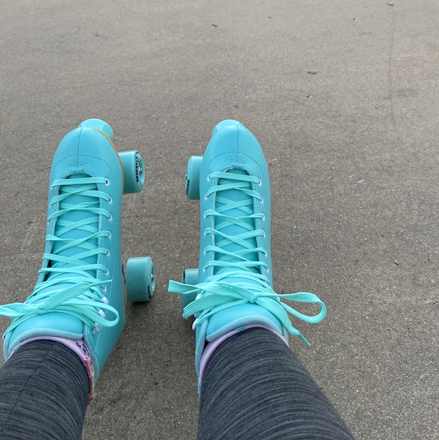 Teal roller skates on an outdoor rink
