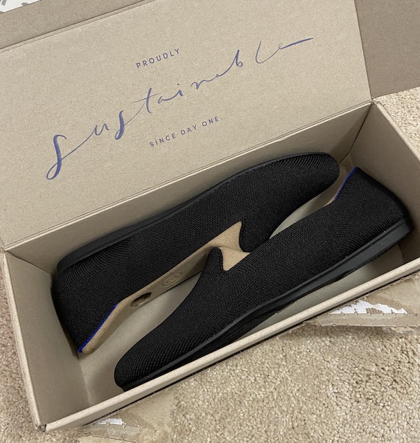 The packaging of black solid Rothy's loafers